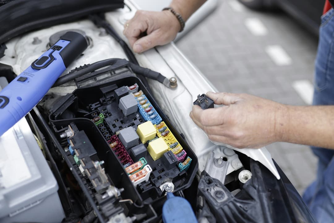 picture of a mobile mechanic doing electrical diagnosis on a fuse box